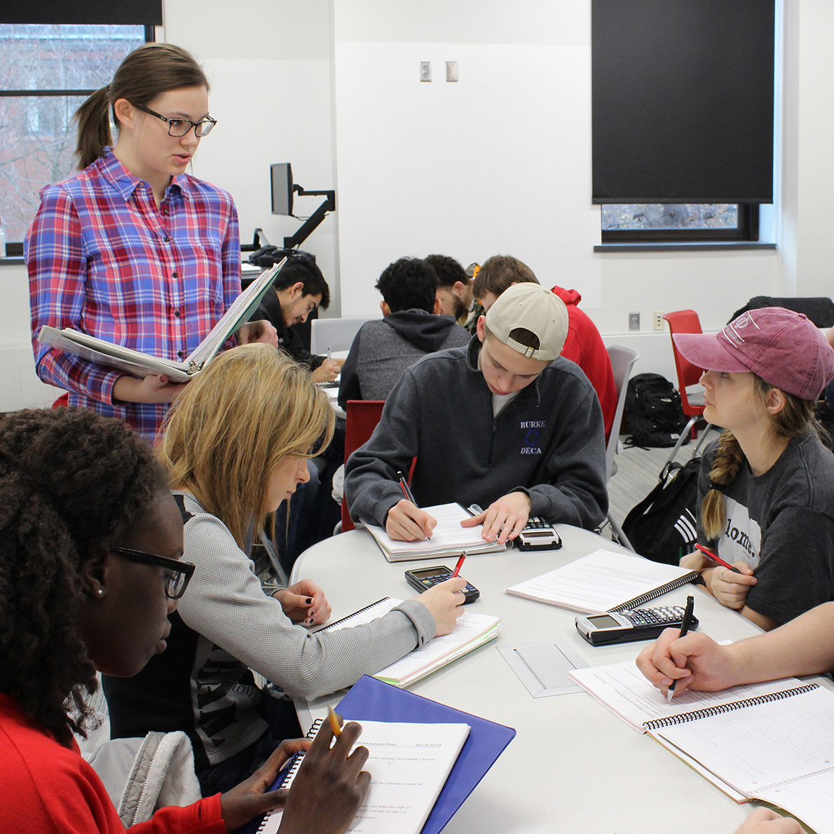 Undergraduate learning assistant Meredith Hovis (left), a secondary mathematics (6-12) major, facilitates group discussions with students in a Math 101 course