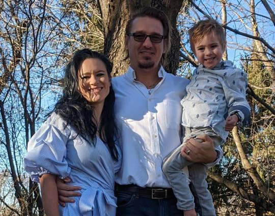 Tomáš Helikar poses outside with his son, Liam, and wife, Resa