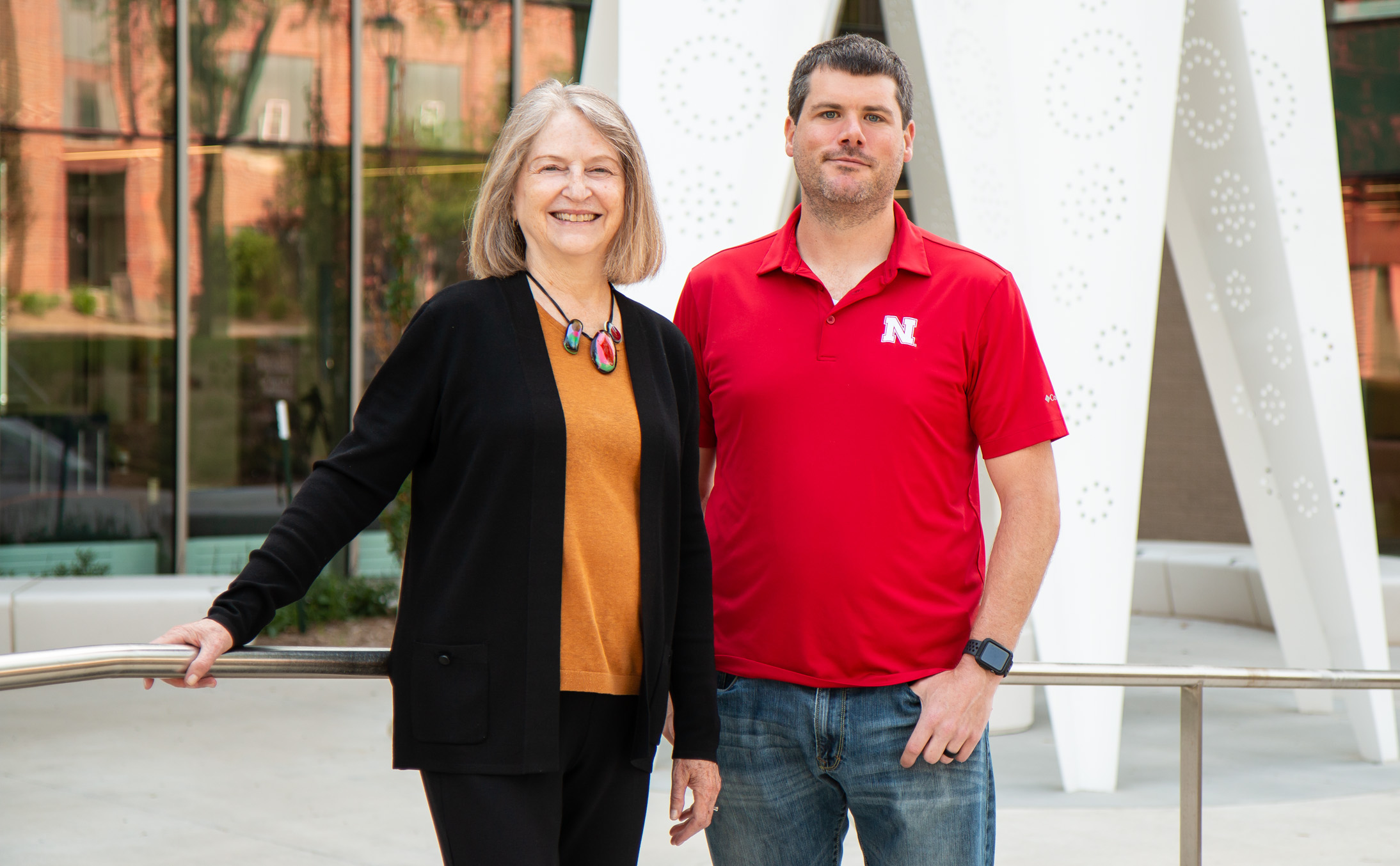 Beth Doll and Matt Cormley stand near a white sculpture outside Carolyn Pope Edwards Hall