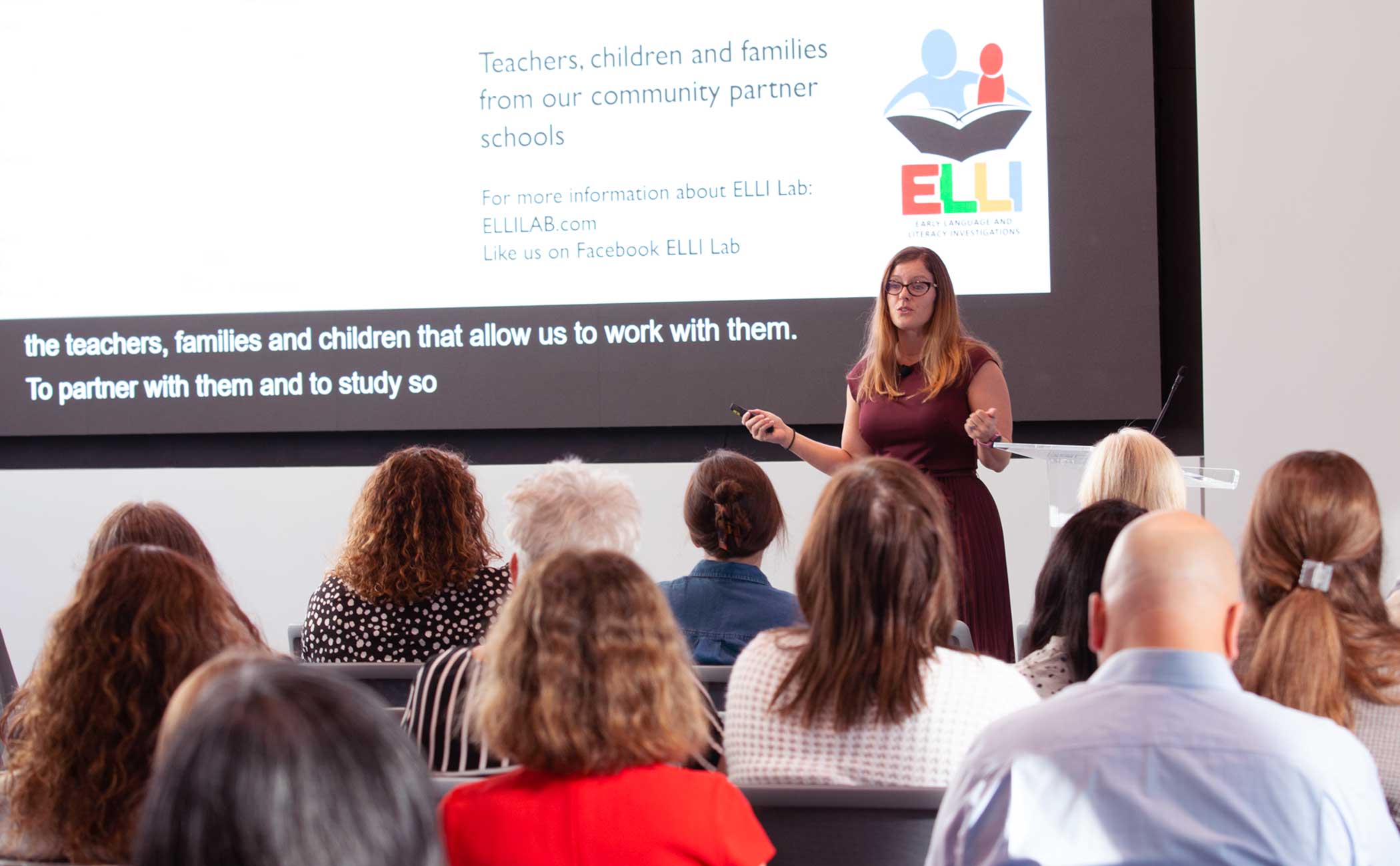 Hope Gerde presents in front of a large group of people in Carolyn Pope Edwards Hall. 