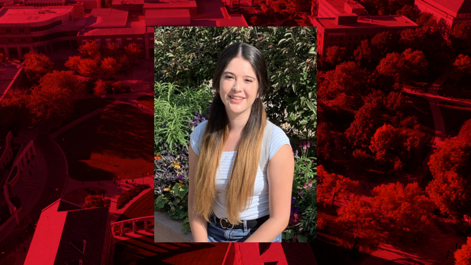 Individual photo on a read background. Individual has long hair and is sitting outdoors smiling for the photo. 