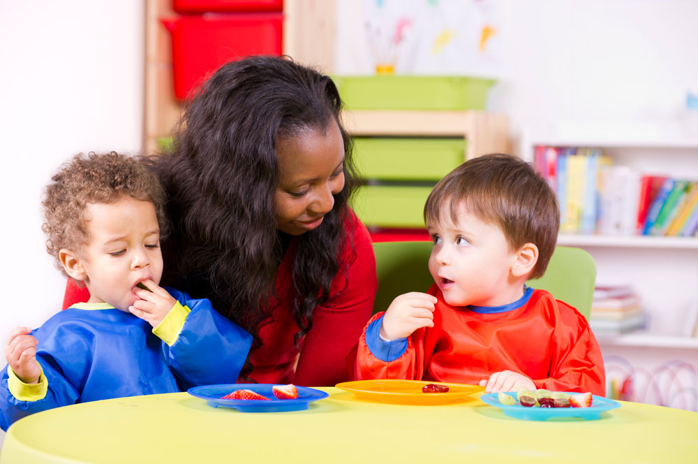 woman eating snacks with two children
