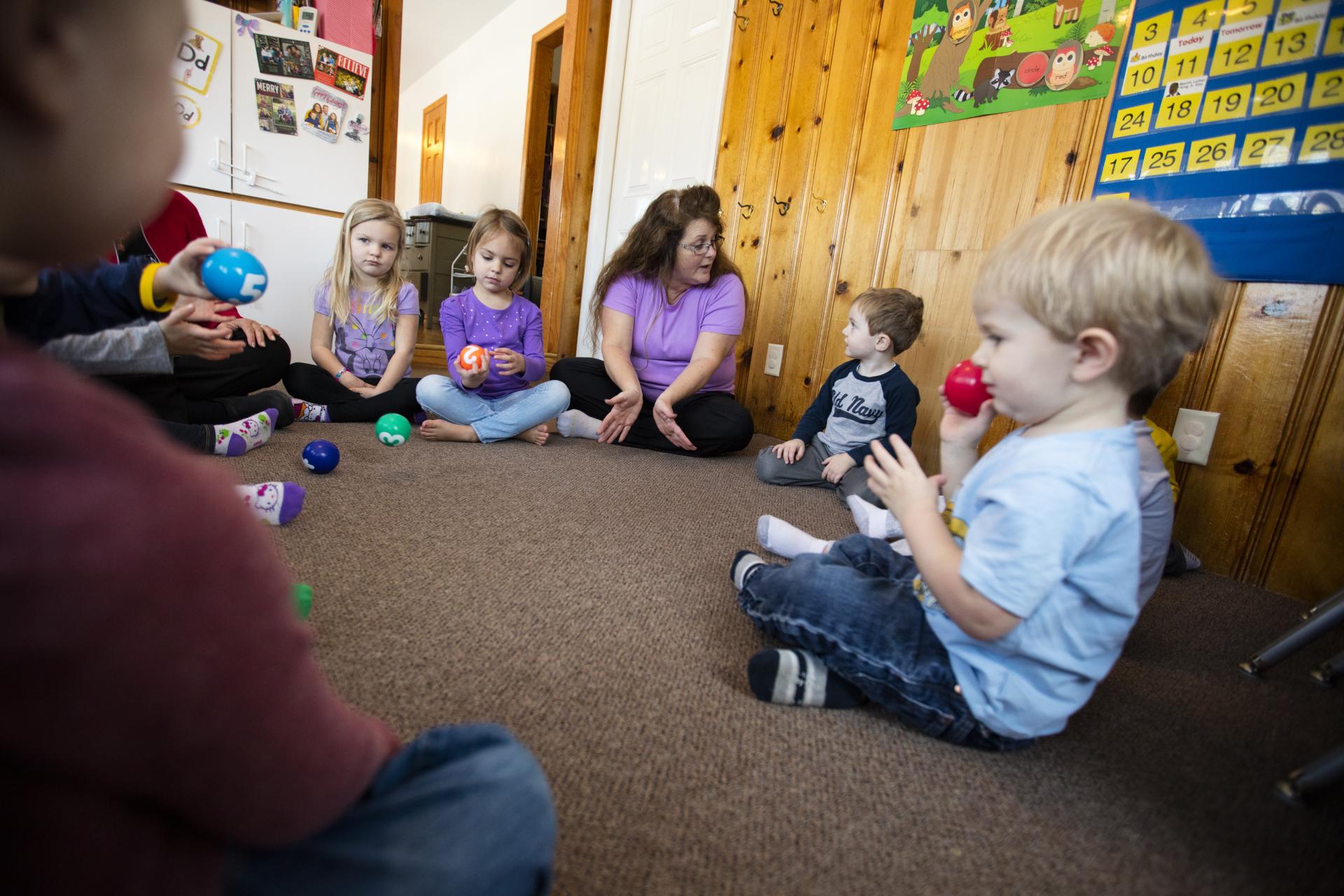 An instructor sitting on the floor with children