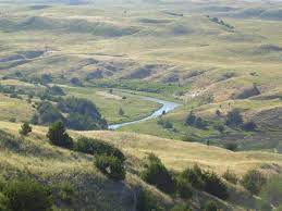 Picture of rolling hills, open landscape, river valley, and small groups of trees.