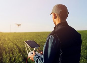 farmer operating drone in field at dawn