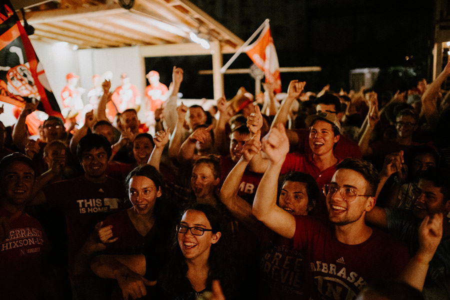 Students at gathering with arms raised